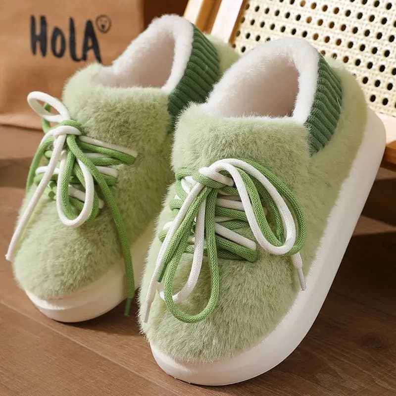 Par de chinelos verdes e brancos com textura de pele de ovelha e cordões.