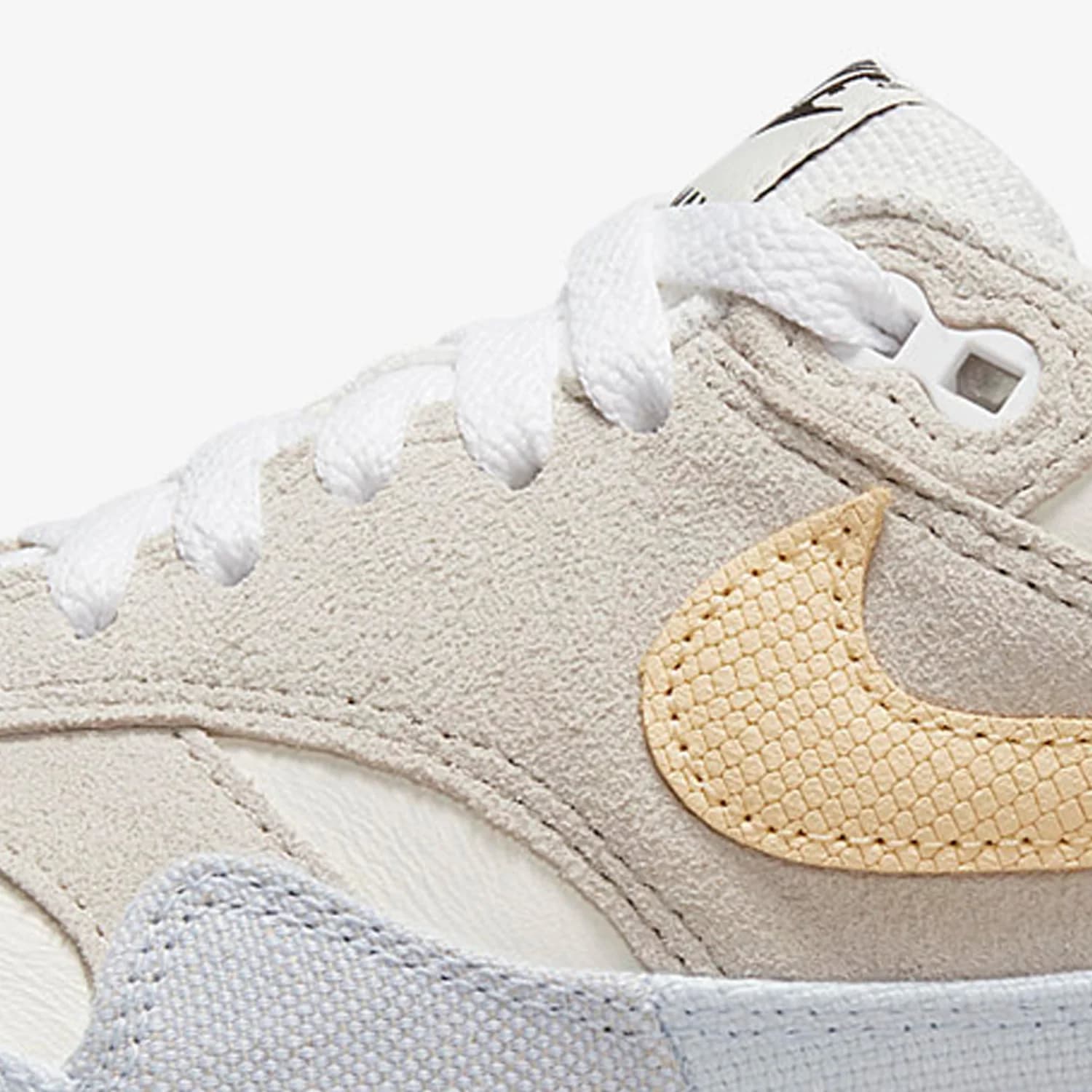 Tênis casual feminino Nike Air Max 1 em camurça off-white com logo amarelo texturizado