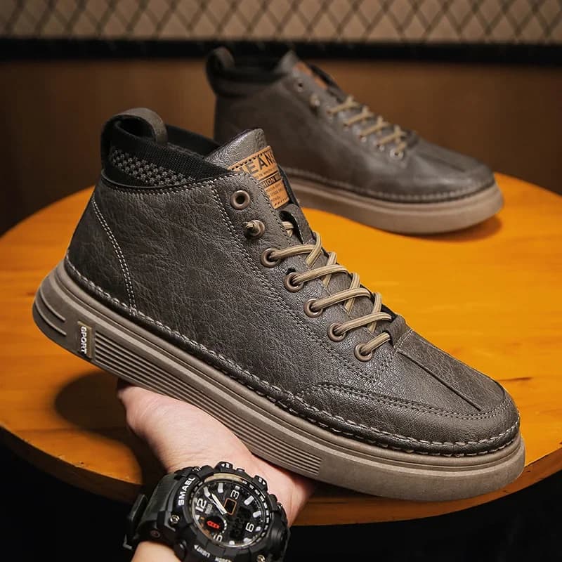 Tênis masculino preto com sola marrom, couro, zíper lateral, cadarços e etiqueta 'JEA'