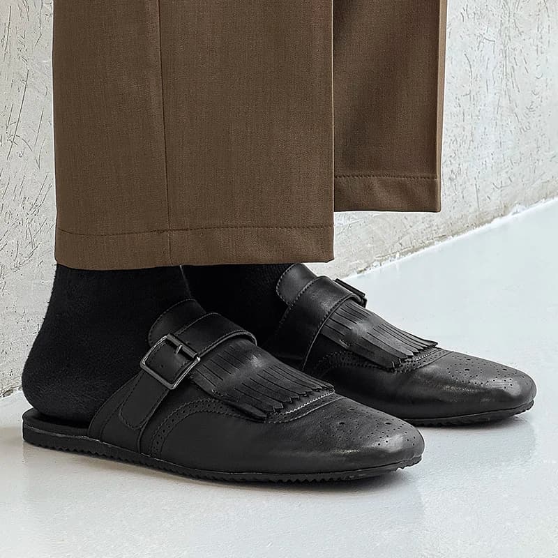 Mocassim masculino preto de couro com tassel usado com meia preta e calça social marrom