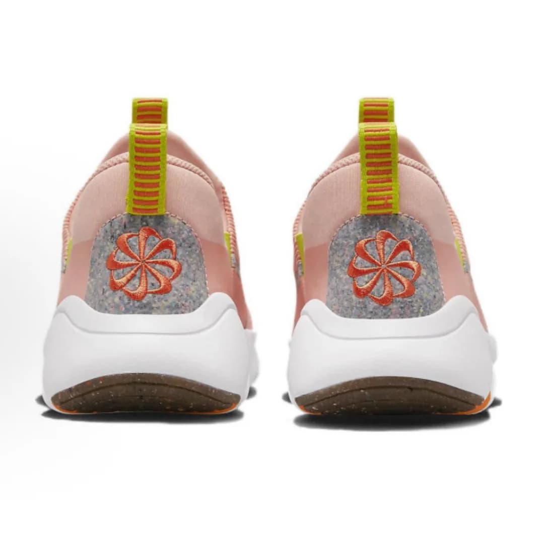 Tênis de corrida feminino Nike rosa pálido com cinza e amarelo, sola preta e branca, cadarço amarelo.
