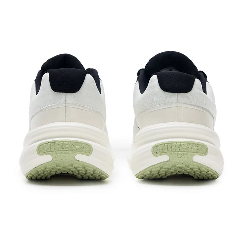 Tênis feminino Nike Uplift SC preto e branco vista traseira com sola verde clara e logo Nike