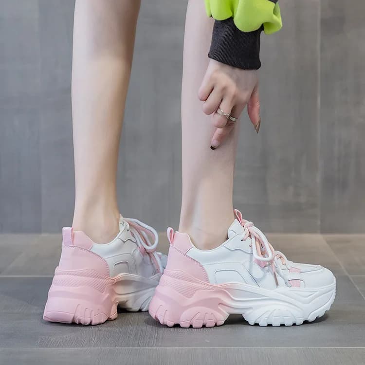 Tênis feminino casual esportivo branco e rosa com cadarço e solado grosso em piso cinza