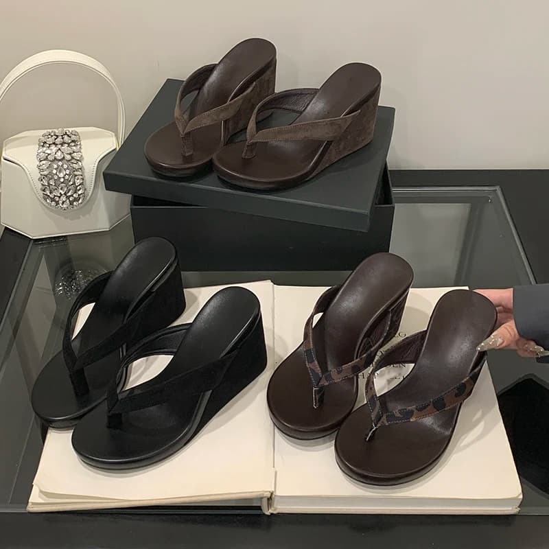 Sandálias de verão pretas e marrons com cunhas grossas em exibição