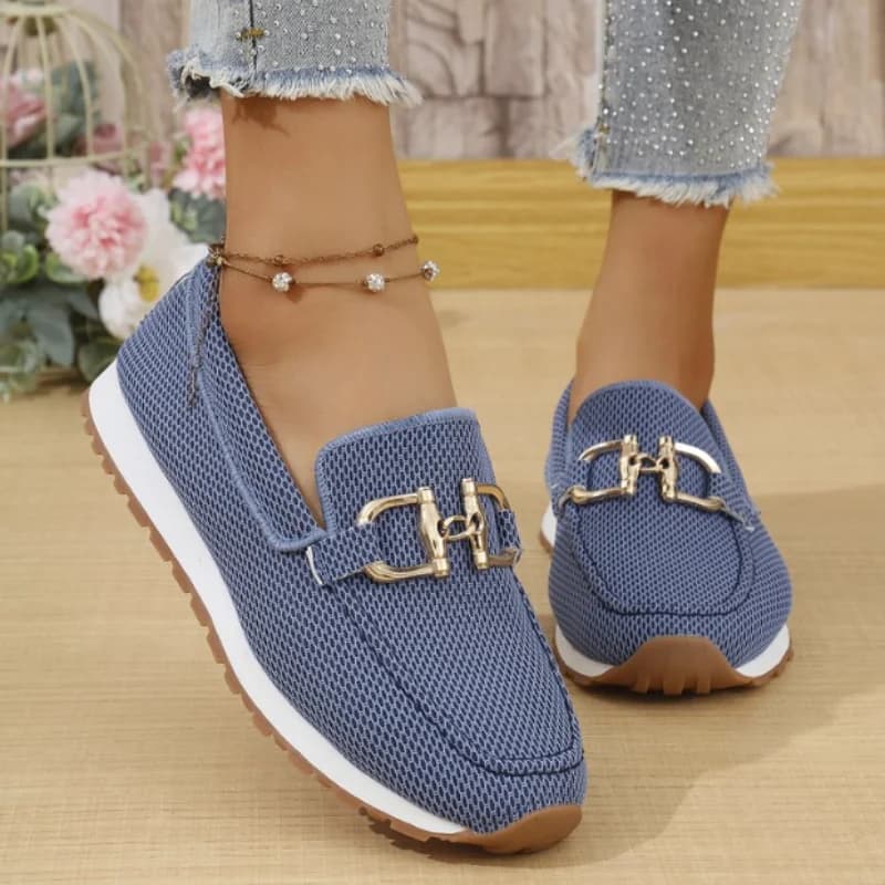Tênis feminino azul marinho com sola branca e marrom, textura de malha e fivelas douradas