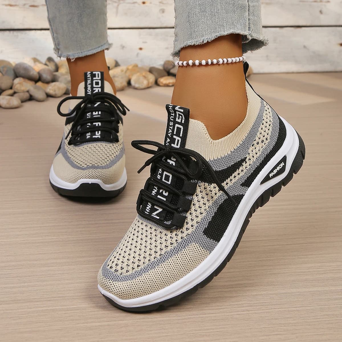 Tênis casual feminino bege com detalhes pretos e cinza, solado preto e cadarço preto