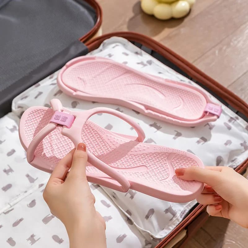 Chinelos de viagem dobráveis antiderrapantes rosa claro em mala aberta com estampa de gatos