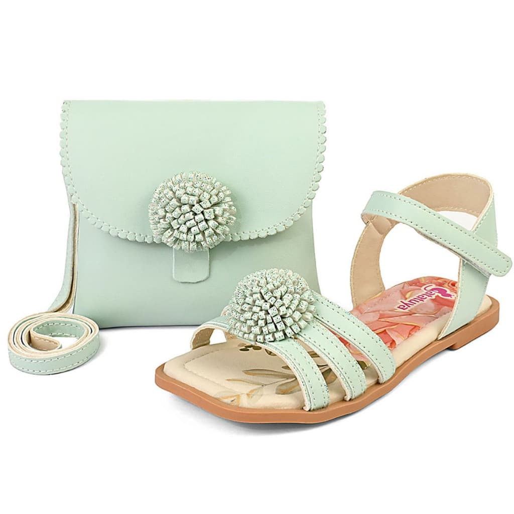 Sandália infantil verde menta com bolsa combinando, detalhes florais rosa e pompons decorativos