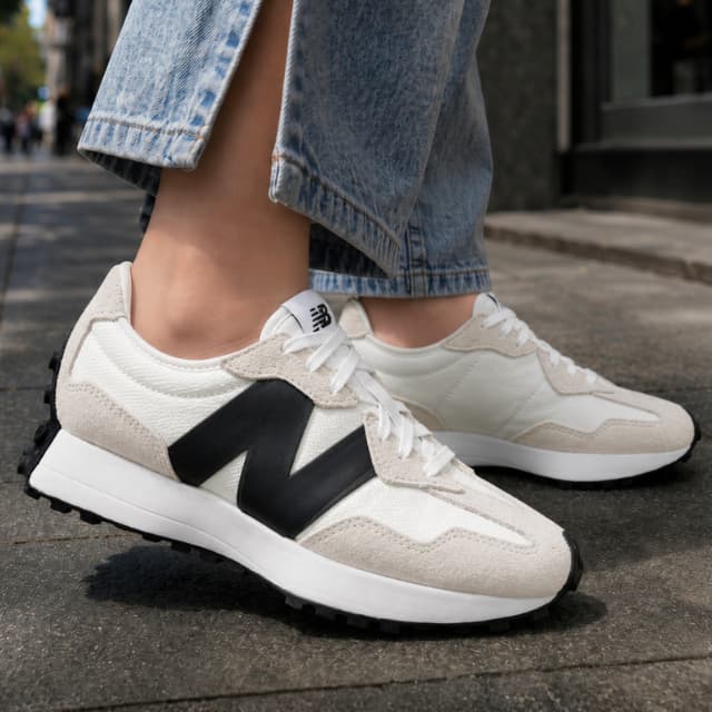 Tênis New Balance 327v1 unissex em off-white, preto e branco com logotipo 'N' na lateral