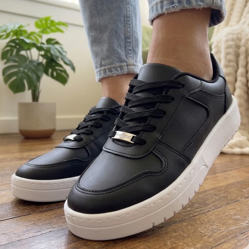 Tênis casual preto com solado branco e detalhes em metal dourado