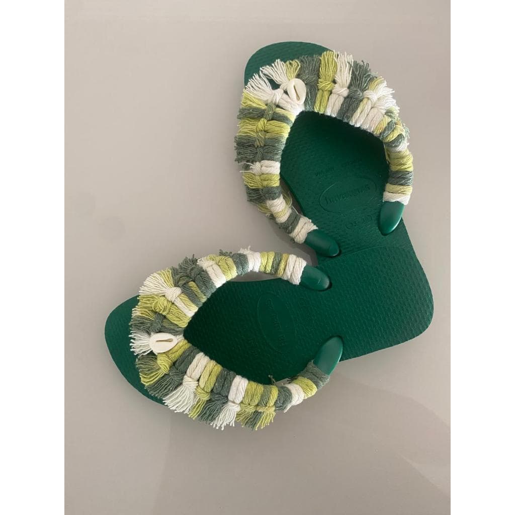 Chinelos verdes com detalhes decorativos brancos e amarelos
