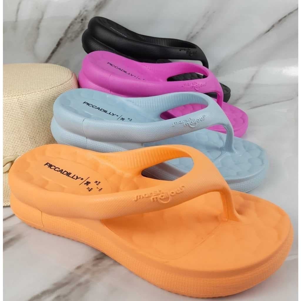 Chinelos puff Piccadilly em cores laranja, rosa, azul e preto sobre fundo marmorizado