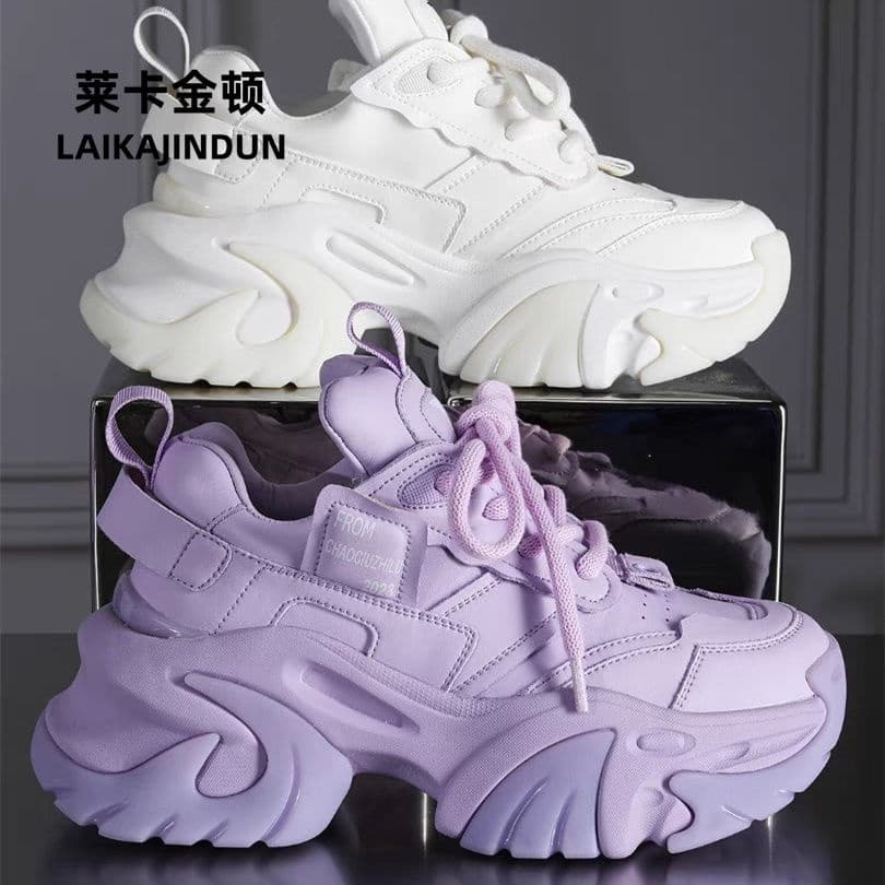 Tênis branco e roxo com sola grossa em ângulos diferentes sobre uma caixa, fundo cinza com texto em chinês.