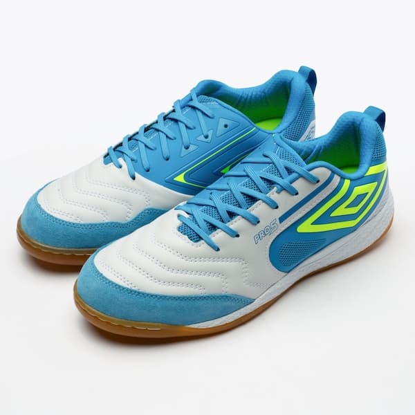 Par de chuteiras Umbro Pro 5 Bump azul e branco, com sola marrom e detalhes verdes.