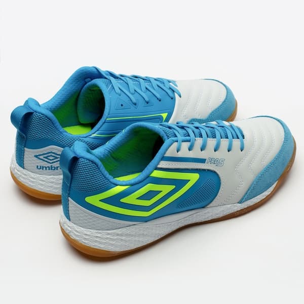 Chuteira Umbro Pro 5 Bump azul e branco, com sola marrom e detalhes verdes, para futsal.