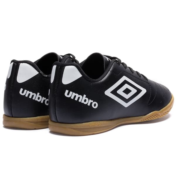 Par de chuteiras futsal infantil Umbro Class 2.2, pretas e brancas, com logo visível.