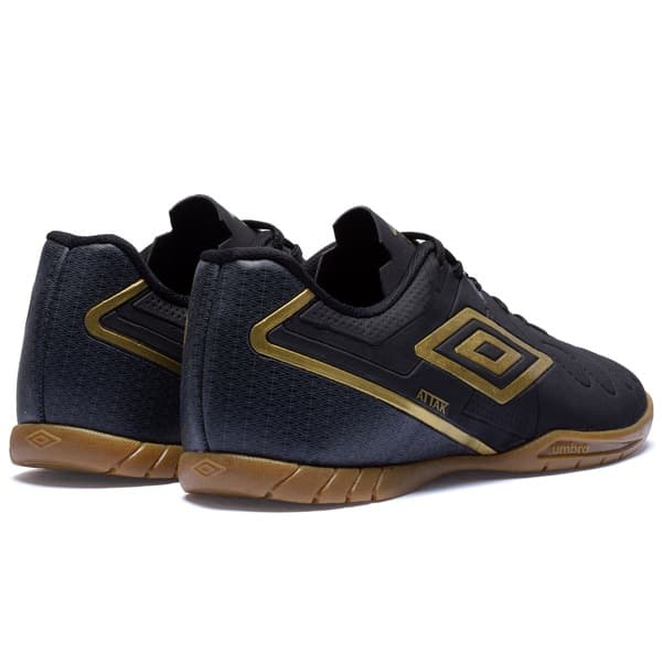 Par de chuteiras futsal Umbro Attak Eternal, pretas com detalhes em dourado.