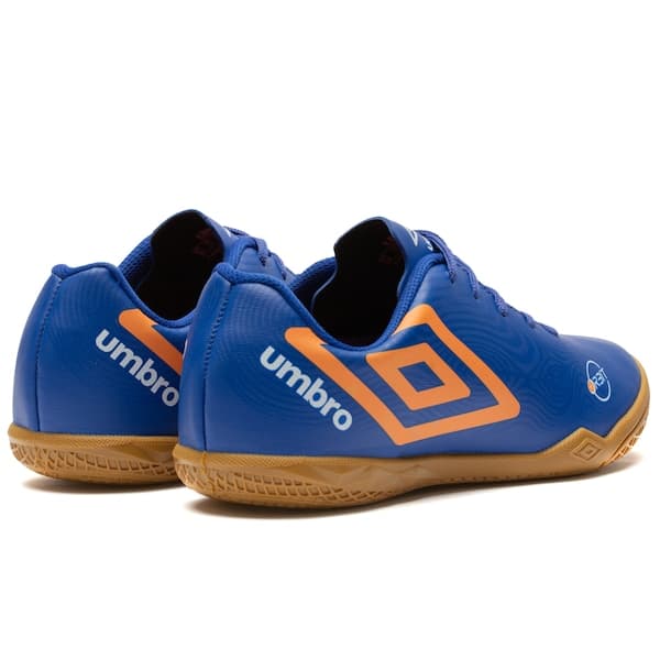 Par de chuteiras futsal infantil Umbro Orbit, azul e laranja, com detalhes em relevo.