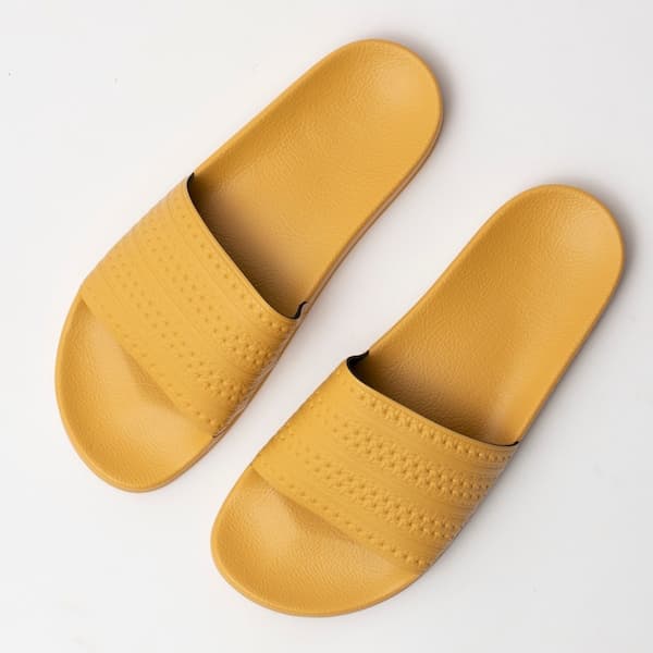 Detalhes das tiras e sola das Adidas Originals Adilette flip flops amarelas.