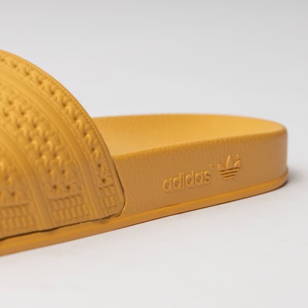 Logo Adidas em destaque na sola das Adidas Originals Adilette flip flops amarelas.