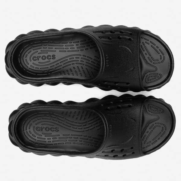 Detalhe da sola texturizada das sandálias Crocs Echo Slide pretas, com logo visível.
