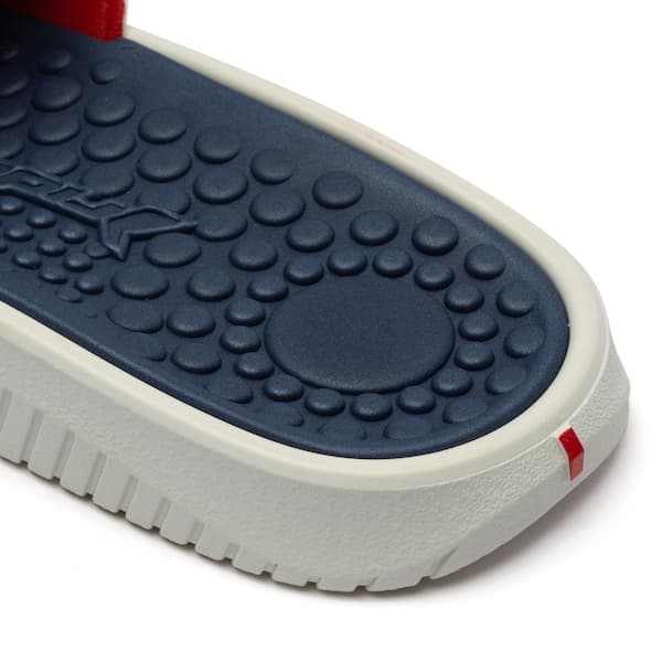 Detalhe da sola pontilhada da sapatilha Rider Pump II Slide Slipper, cor azul e branco.