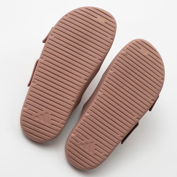 Detalhe da sola da sandália minimalista Adidas Znsory em couro sintético marrom, com logo Adidas.