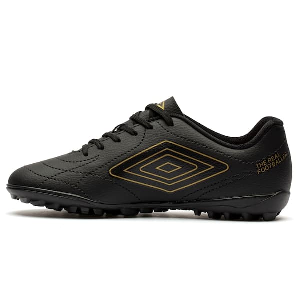 Detalhe da chuteira society Umbro Class Footballer, preta e dourada, com logo.