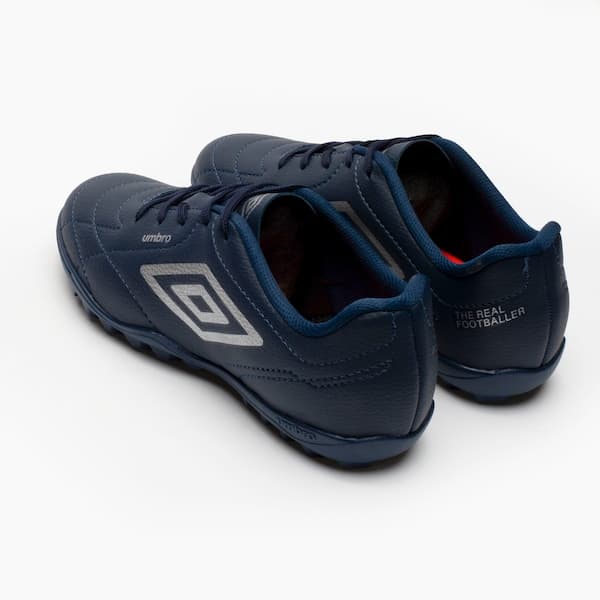 Tênis de futebol Umbro Class Society Kids, azul marinho com logo branco e sola de borracha.