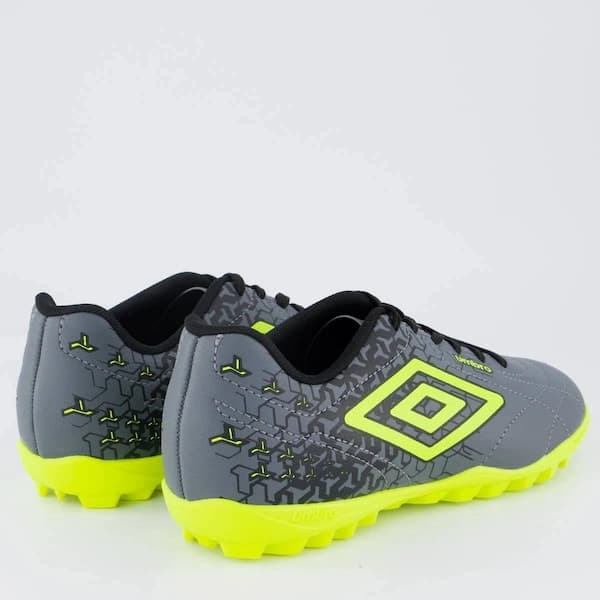 Par de tênis Umbro Class Neo para futebol em preto, cinza e amarelo, com detalhes do logotipo e design.