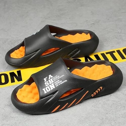 Chinelos massagem BEMMY Nuvem preto e laranja sobre superfície de concreto.