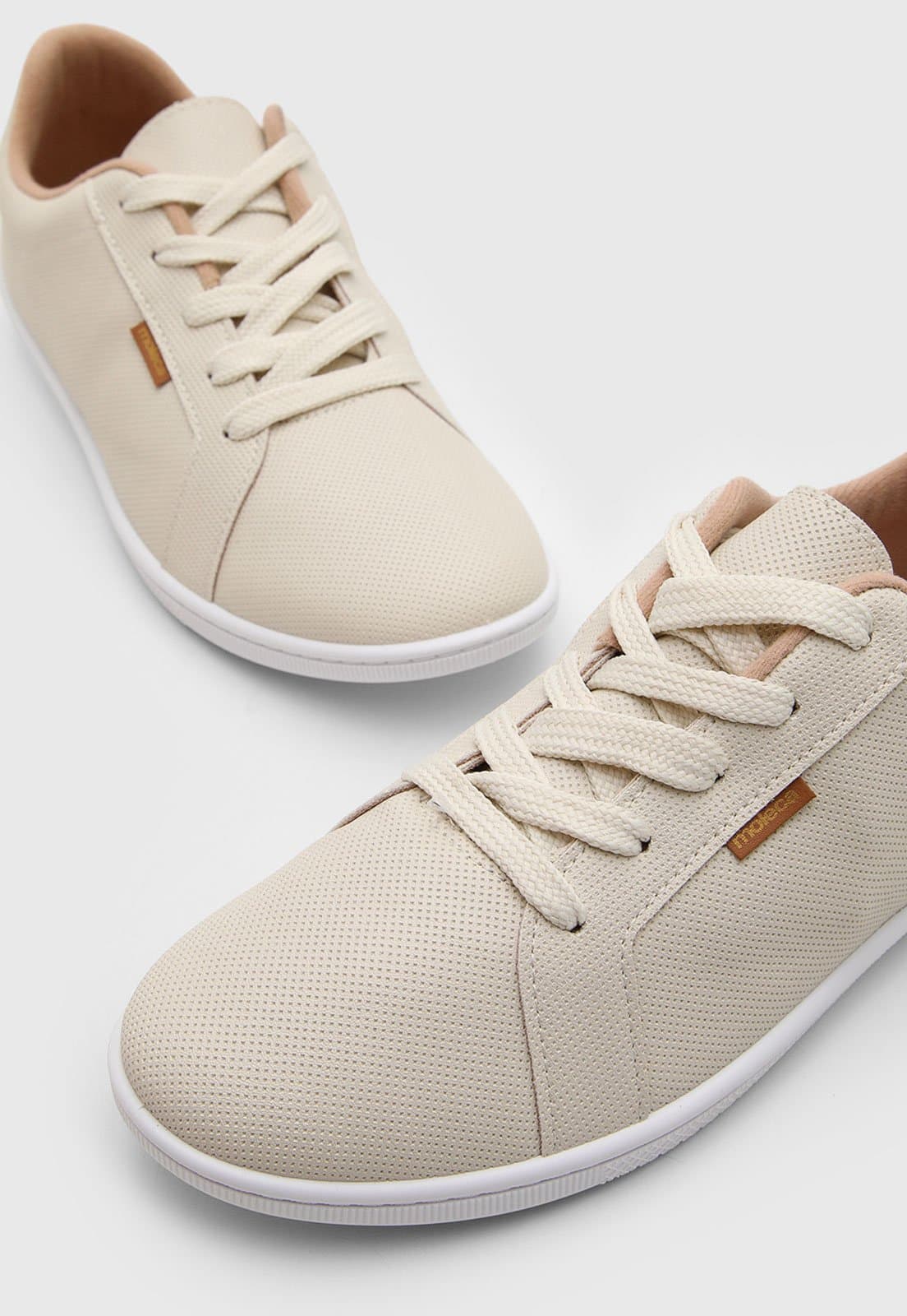 Par de tênis Moleca Casual Off White com sola flat e cadarço branco, estilo low top.
