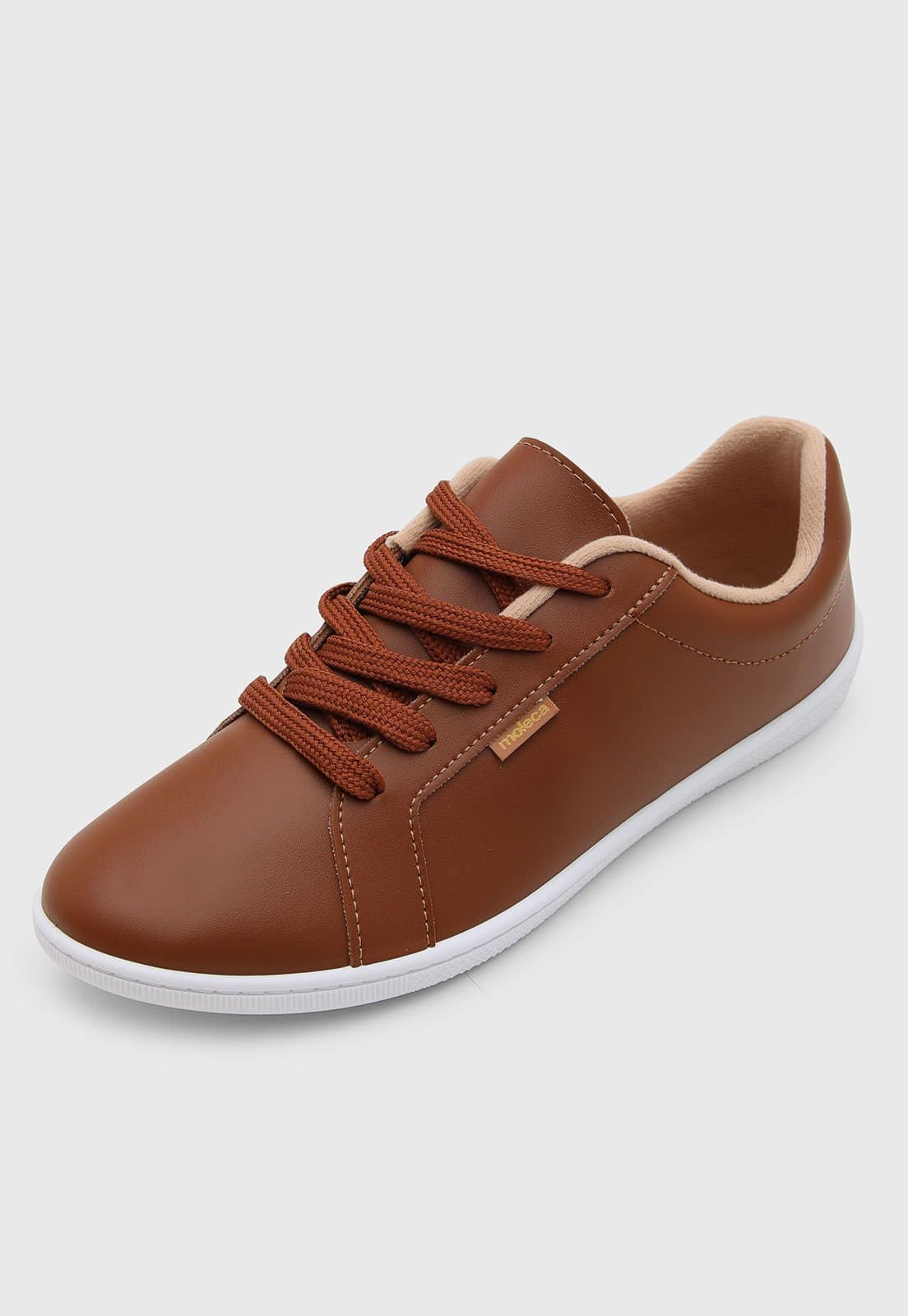 Detalhe do tênis feminino Moleca marrom sintético, com cadarços e sola branca.