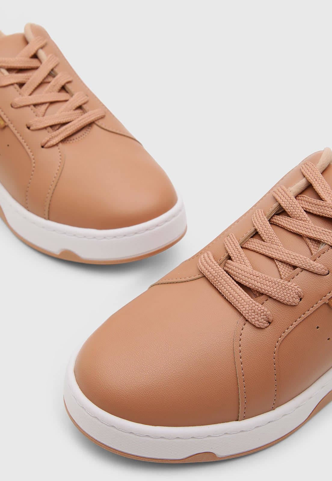 Detalhe dos cadarços do tênis Moleca feminino casual em couro sintético nude.