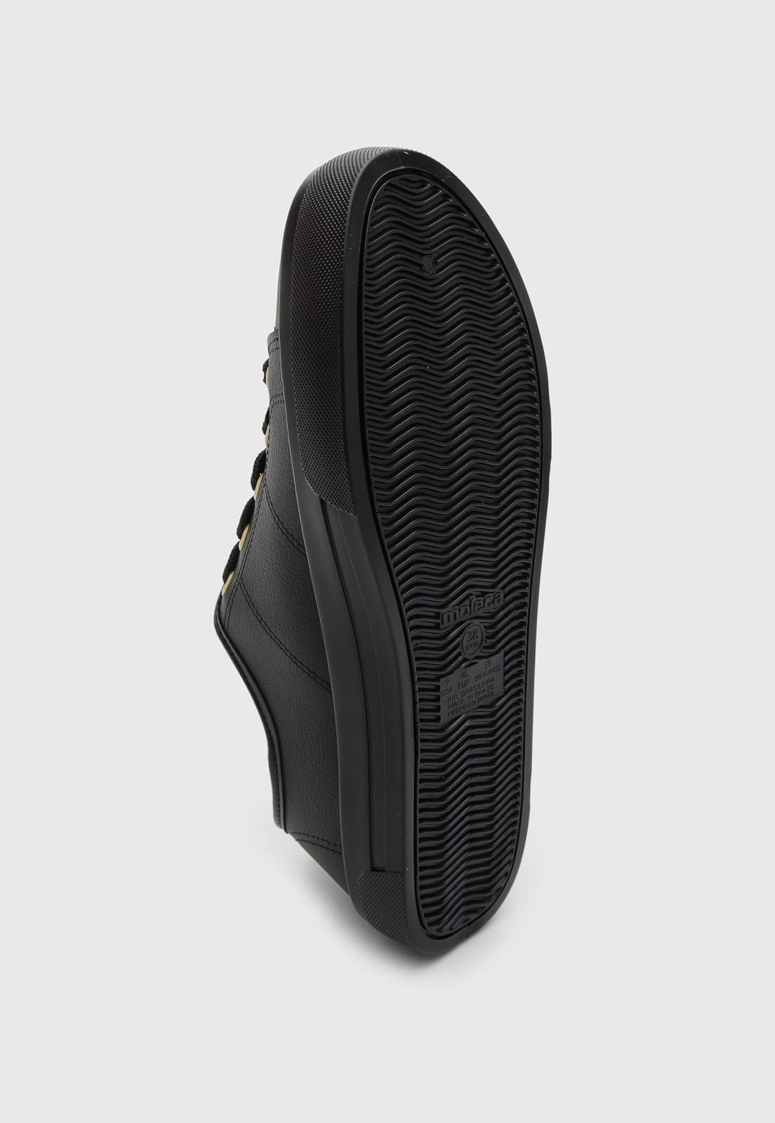 Detalhe da sola do tênis feminino casual Moleca preto com logo e informações.
